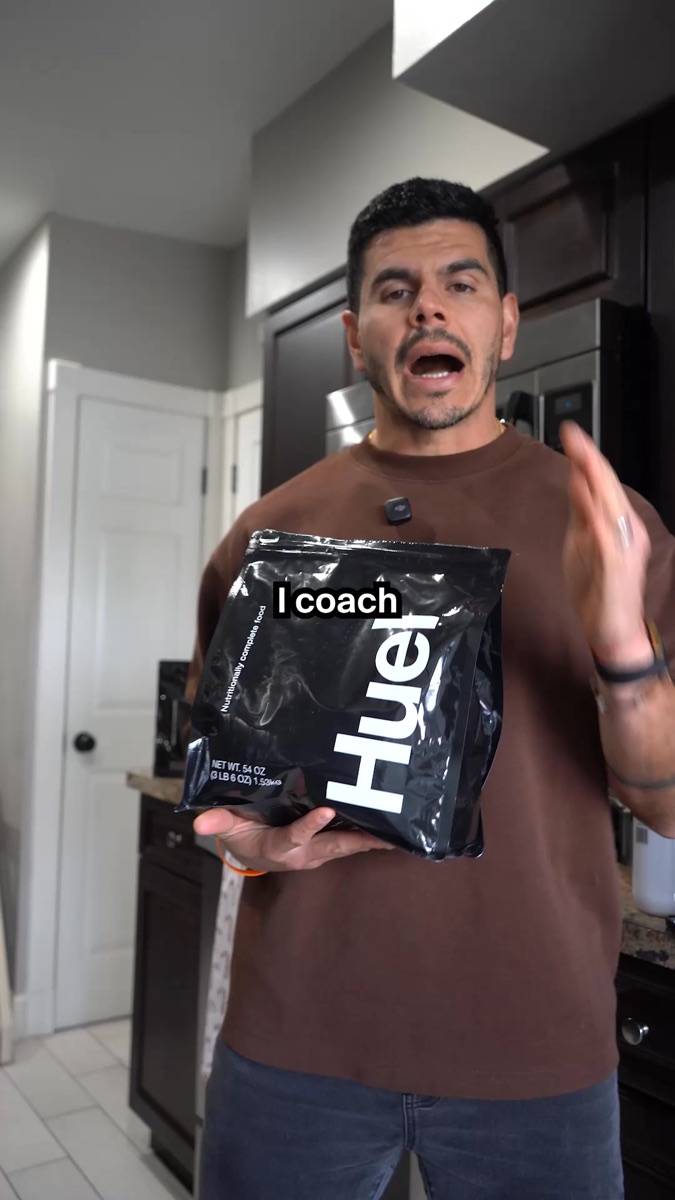Male creator holding a Huel product in a kitchen